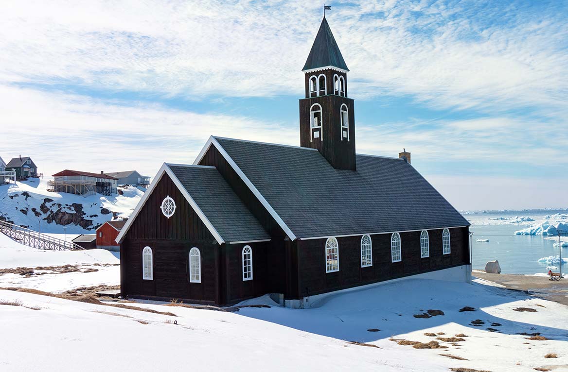 Zion church in Ilulissat Greenland with sunny snowy landscape .
