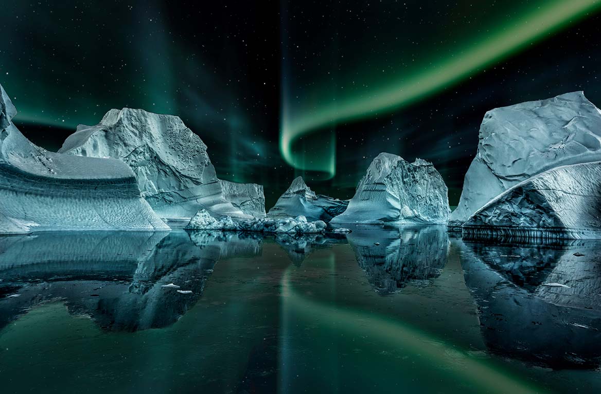 North Atlantic Traveling. Icebergs floating under the Northern lights sky.