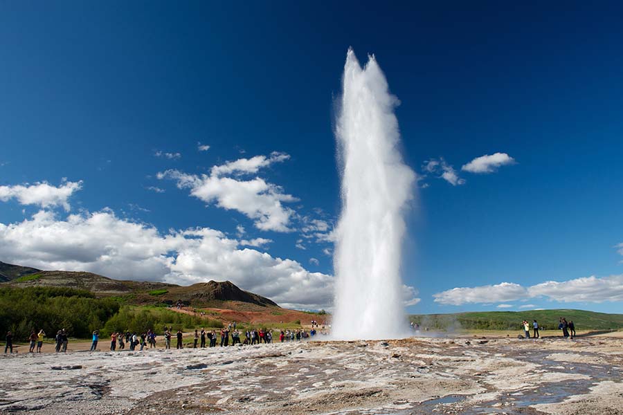Impressive eruption of the biggest active geysir, Strokkur, with tourists waiting around, Golden circle, Iceland