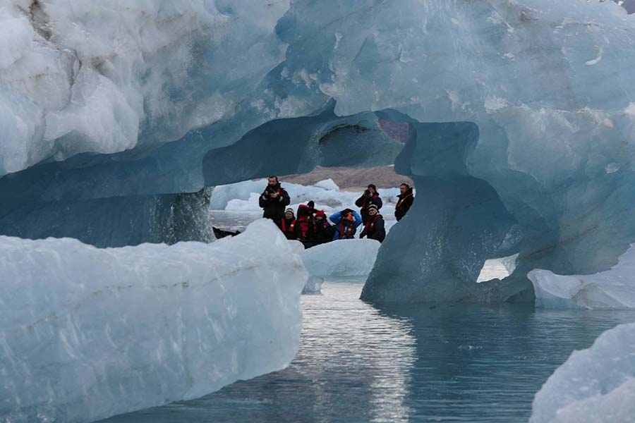 Togo passengers on zodiac cruising among icebergs 900x600